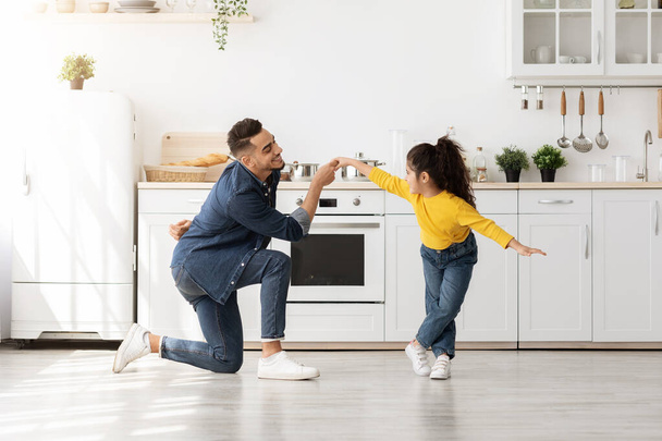 Cheerful arab father dancing with his cute little daughter at home - Photo, Image