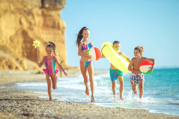 Cute children enjoying sunny day at beach. Summer camp - 写真・画像