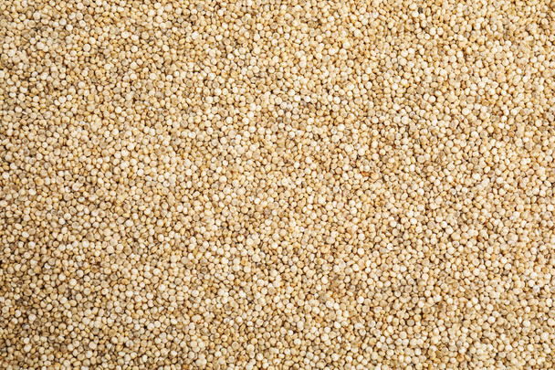 Heap of white quinoa as background, top view. Veggie seeds - Фото, изображение
