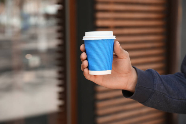 Man with takeaway coffee cup outdoors, closeup - Foto, imagen