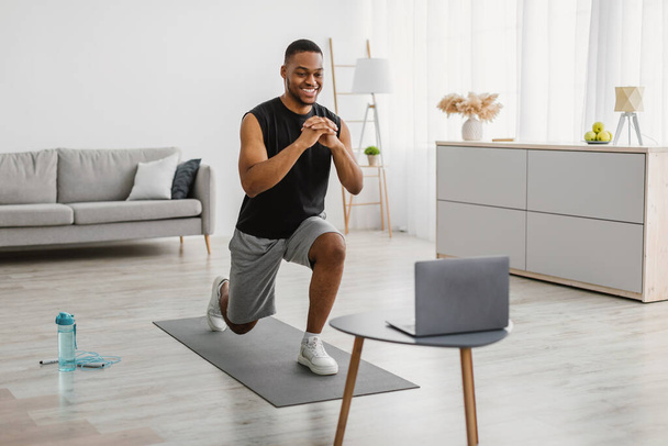 Afrikaner macht Vorwärts Lunge Übung beobachten Online Workout Indoor - Foto, Bild