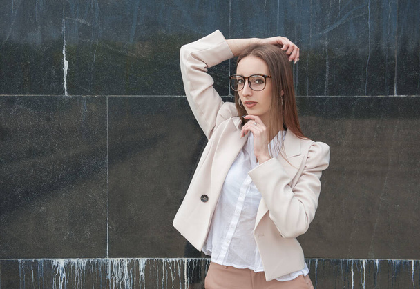 Gyönyörű fiatal divat stílusos nő a falon város háttér - Fotó, kép