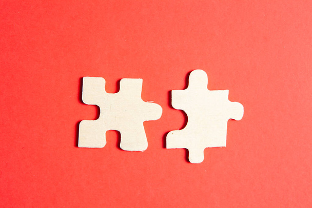 twee puzzelstukjes op een rode achtergrond - Foto, afbeelding