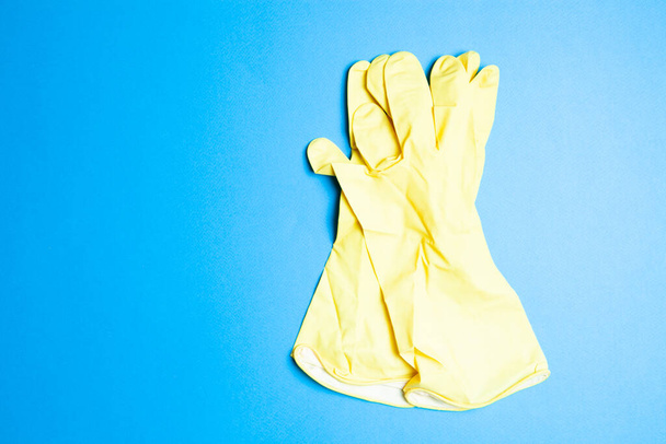 yellow rubber gloves on a blue background - Photo, Image