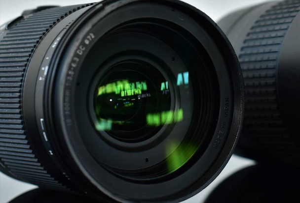 Teleobjektive für eine Spiegelreflexkamera liegen auf einem Glastisch  - Foto, Bild