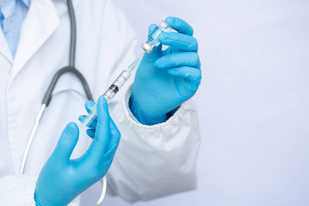 Médico ou cientista em laboratório segurando uma seringa com vacinas líquidas. Concept luta contra o vírus covid-19 corona vírus. - Foto, Imagem