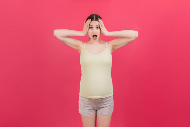 Young surprise or shocked woman pregnant isolated colored background. expression female. - Photo, Image