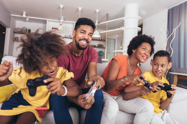 Famille afro-américaine jouer à des jeux vidéo ensemble et avoir du plaisir à la maison - Photo, image