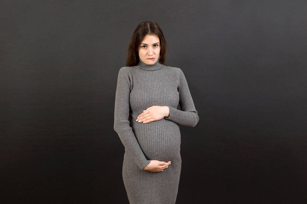 Sad and stressed pregnant woman isolated on colored background. - Foto, Imagem