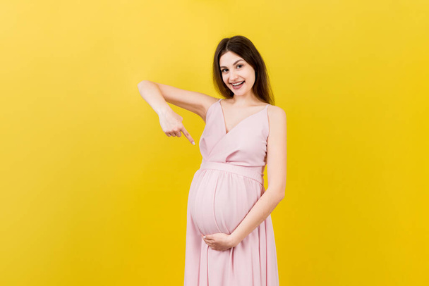 Jonge verrassing of geschokte vrouw zwanger geïsoleerde gekleurde achtergrond. uitdrukking vrouwelijk. - Foto, afbeelding