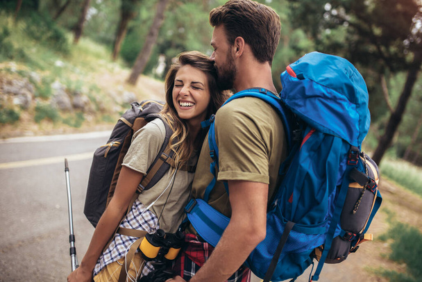 Jeunes randonneurs souriants heureux marchant dans la forêt pendant le voyage de camping.  - Photo, image