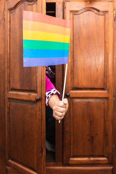 Ruka neznámé osoby vycházející ze skříně s vlajkou homosexuální hrdosti. Vylez ze skříně. Koncept komunity Lgbt. selektivní zaměření. - Fotografie, Obrázek