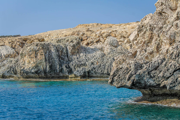 Small backwater surrounded by a stone cliff with azure water in Cyprus - Photo, Image