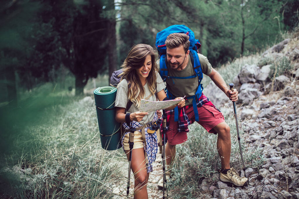 Couple hiking trough forest. Using map to get good direction. - Photo, Image