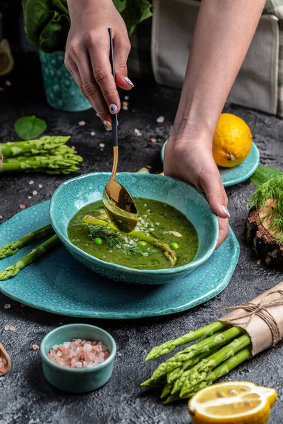 Homemade asparagus soup with fresh raw stems of asparagus, vertical image, place for text, - Photo, Image
