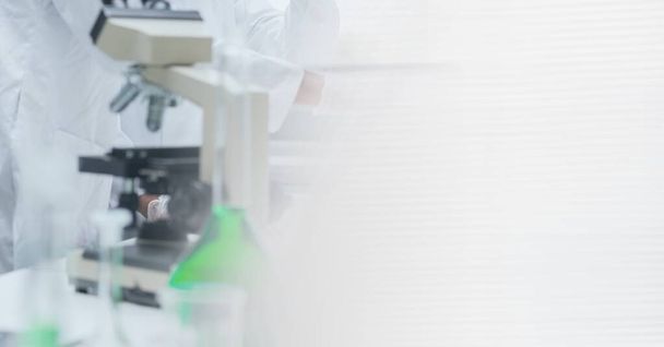 Composition of female scientist in lab using microscope with motion blur. science and research technology concept digitally generated image. - Фото, изображение