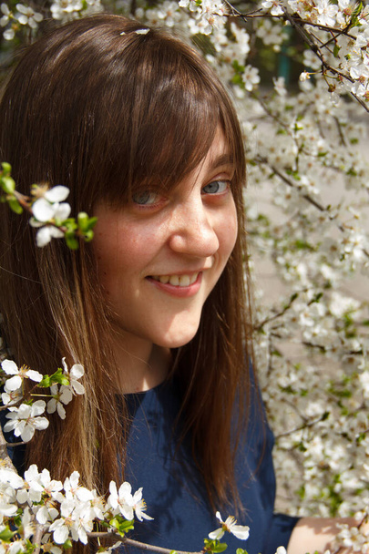 The girl is in a white flowering tree - Foto, Imagen