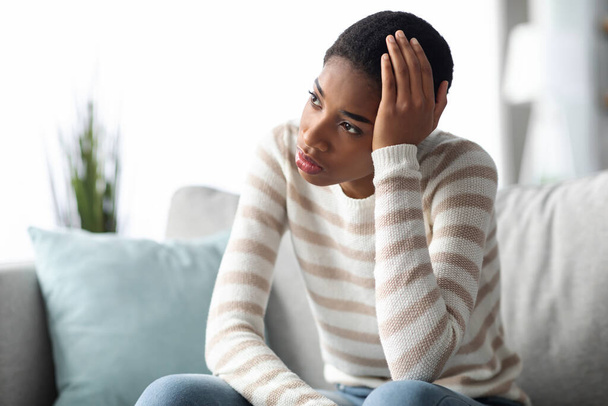 Концепція депресії. Портрет афроамериканської жінки сидить на дивані
 - Фото, зображення