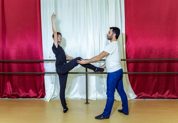 učitel učí mladého chlapce tančit ve studiu, mladý chlapec cvičí v tanečním studiu - Fotografie, Obrázek