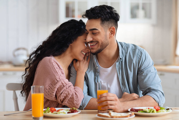 キッチンで朝食をしながら幸せなロマンチックなアラブカップルの絆 - 写真・画像