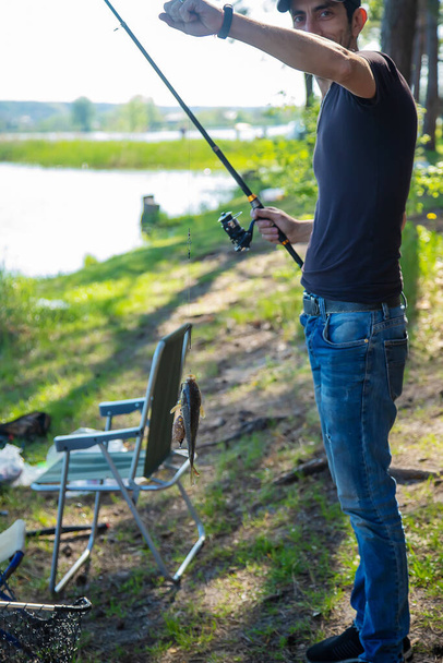 Ένας άντρας ψαρεύει στη λίμνη. Επιλεκτική εστίαση. Φύση. - Φωτογραφία, εικόνα