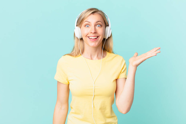young blonde woman feeling happy, surprised realizing a solution or idea and listening music. - Photo, Image