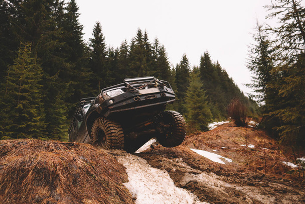 El coche todo terreno salta en las montañas. Polen, pantano y nieve. Afortación, suspensión, neumáticos - Foto, imagen