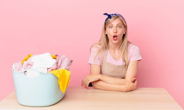 young blonde woman looking very shocked or surprised. wash clothes concept - Foto, immagini
