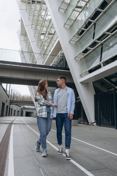 photo of the young couple in love walking around the day city among skyscrapers  - Фото, зображення