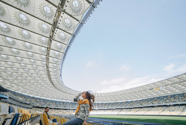photo of a couple posing on camera at the empty field stadium - Фото, изображение