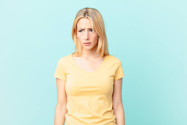 young blonde woman feeling sad, upset or angry and looking to the side - Foto, imagen