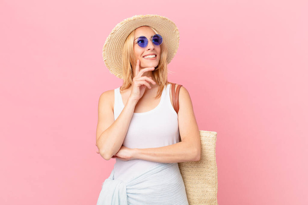 young blonde woman smiling happily and daydreaming or doubting. summer concept - Fotoğraf, Görsel