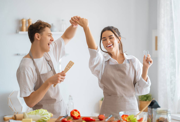 Healthy food at home. Happy loving couple is preparing the proper meal in the kitchen. - Foto, Imagen