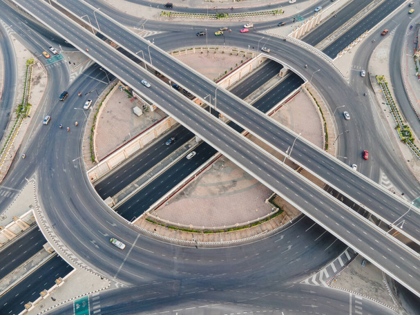 Luftaufnahme einer Straßenkreuzung mit Kreisverkehr. Stadtautobahn-Kreuzung mit überhöhter Geschwindigkeit. Knotenpunkt-Transportnetz per Drohne. - Foto, Bild
