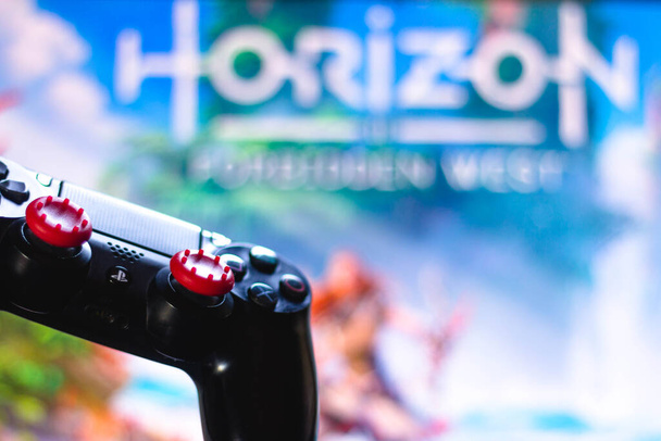 17 de maio de 2021, Brasil. Nesta foto ilustração o controlador para PlayStation (PS) e em segundo plano o logotipo do jogo Horizon Forbidden West - Foto, Imagem