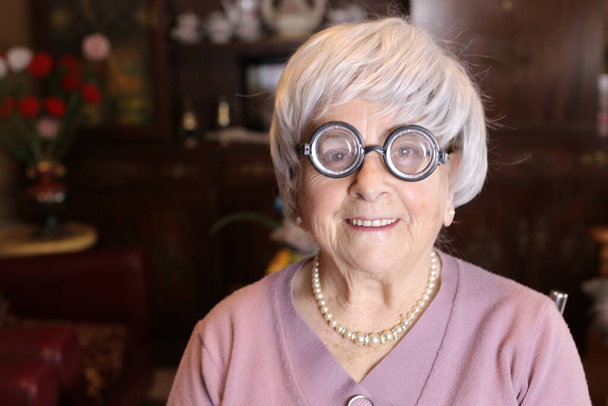 zblízka portrét dospělé ženy s kulatými brýlemi doma - Fotografie, Obrázek
