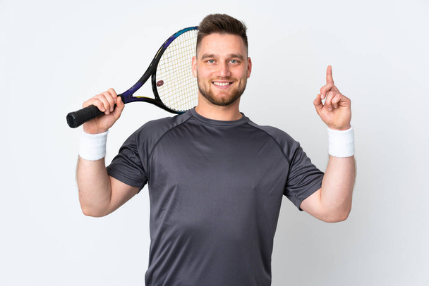 Beyaz arka planda izole edilmiş Rus yakışıklı adam tenis oynuyor ve yukarı işaret ediyor. - Fotoğraf, Görsel