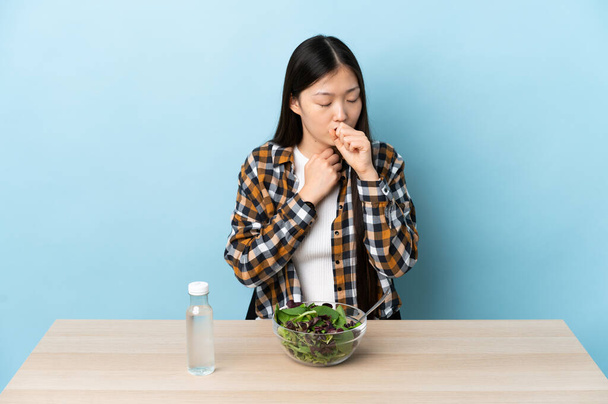 Młoda chińska dziewczyna jedząca sałatkę kaszle dużo - Zdjęcie, obraz