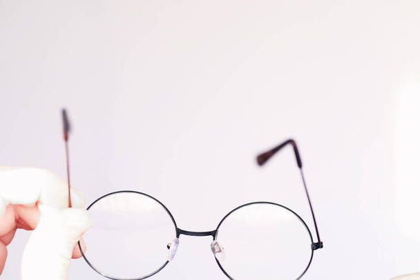 Das Konzept der Sehschwäche. Halten Sie eine Kontaktlinse und eine Brille in der Hand. Poster für Werbebrillen und -gläser. - Foto, Bild