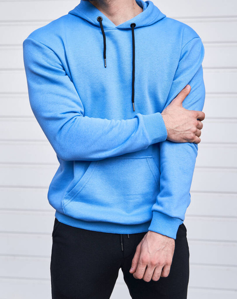 Człowiek z brodą stojący w lazurowej bluzie. Jasnoniebieska bluza bez logo. Makieta projektowa - Zdjęcie, obraz