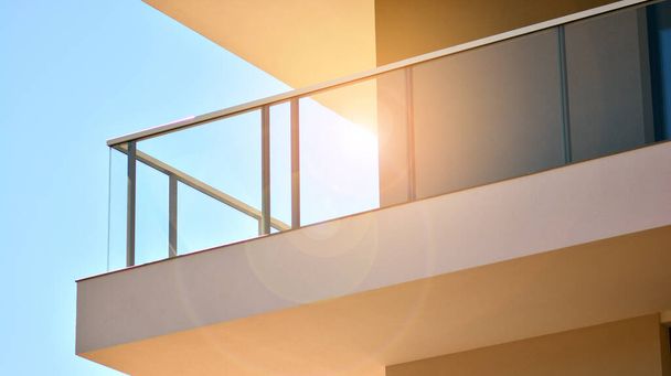 Архитектура фасадов жилых домов и домов, наружные сооружения. Многоэтажный современный, новый и стильный жилой блок из квартир. Голубое небо на фоне. Солнечный свет на рассвете. - Фото, изображение