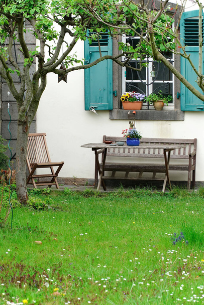 A vertical shot of garden furniture in front of a white-coated building at Kloster Heisterbach, Germany - Foto, Bild