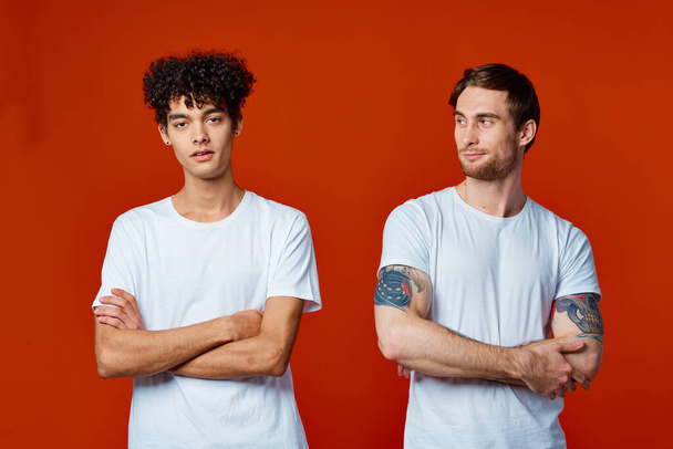 два друга в белых футболках стоят бок о бок изолированное фоновое общение - Фото, изображение