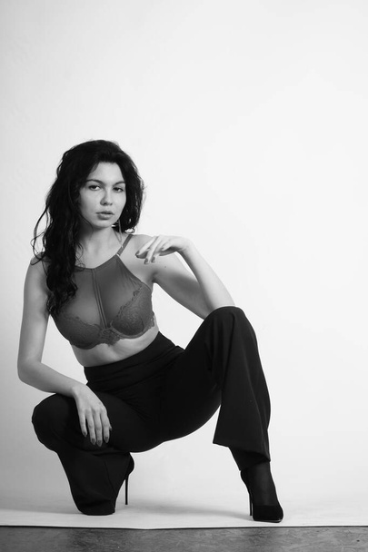 sexy bela morena mulher em lingerie e moderno sino bottoms calças posando no estúdio no fundo branco  - Foto, Imagem