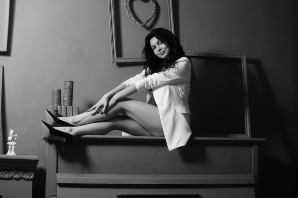 krásná brunetka žena ve spodním prádle a bílé sako pózování na klavír ve studiu  - Fotografie, Obrázek