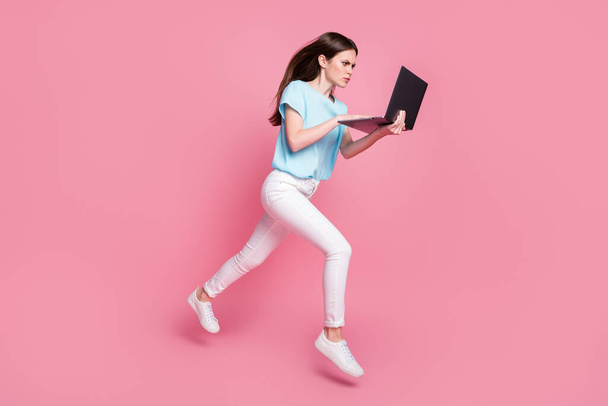 Full body photo of focused girl jump use laptop sales wear blue white sneakers isolated pastel color background - Foto, imagen