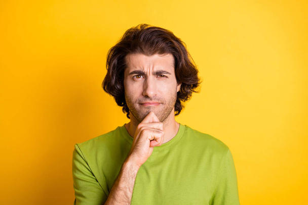 Photo of pensive bearded clever guy finger chin look camera wear green t-shirt isolated yellow color background - Foto, Imagem