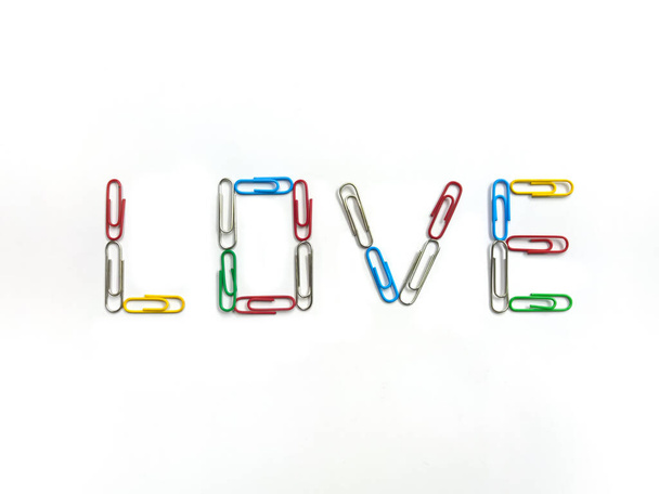 Väri klemmarit järjestetty rakastaa sanaa valkoisella taustalla - Valokuva, kuva