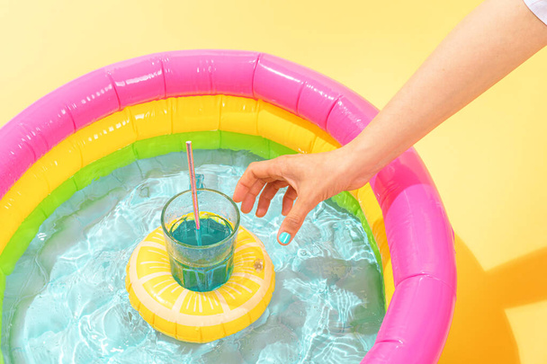 neznámá osoba si vezme citrónový nafukovací koktejl do dětského bazénu - Fotografie, Obrázek