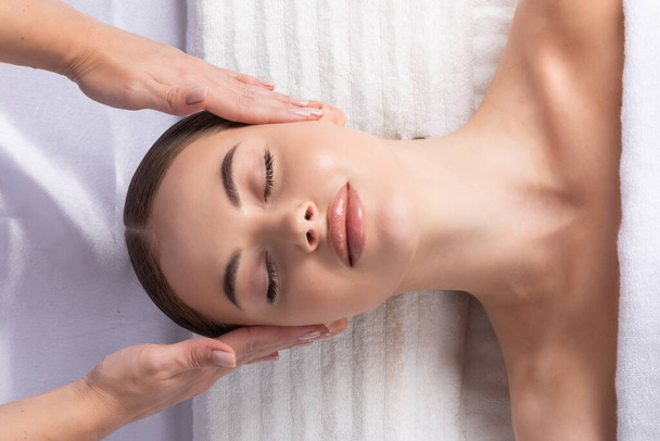 Young beautiful lady getting spa treatment face massage - Fotografie, Obrázek